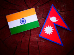 Indian flag with Nepali flag on a tree stump isolated